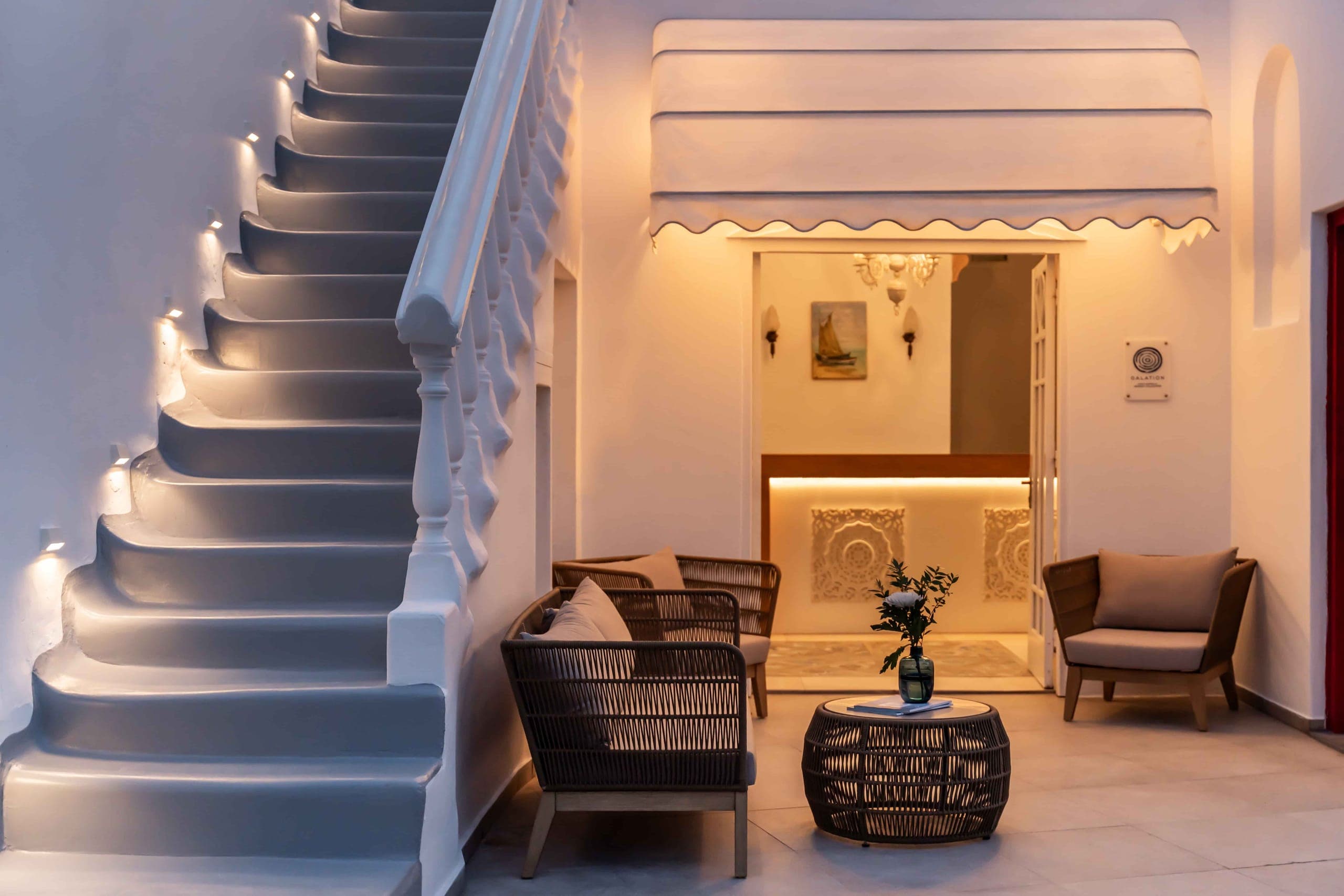 Lit staircase and lounge seating at the hotel entrance in the evening